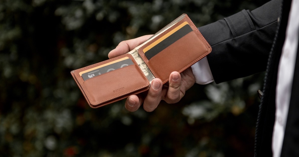 Hombre que sostiene una billetera de secretaria modular Ekster.