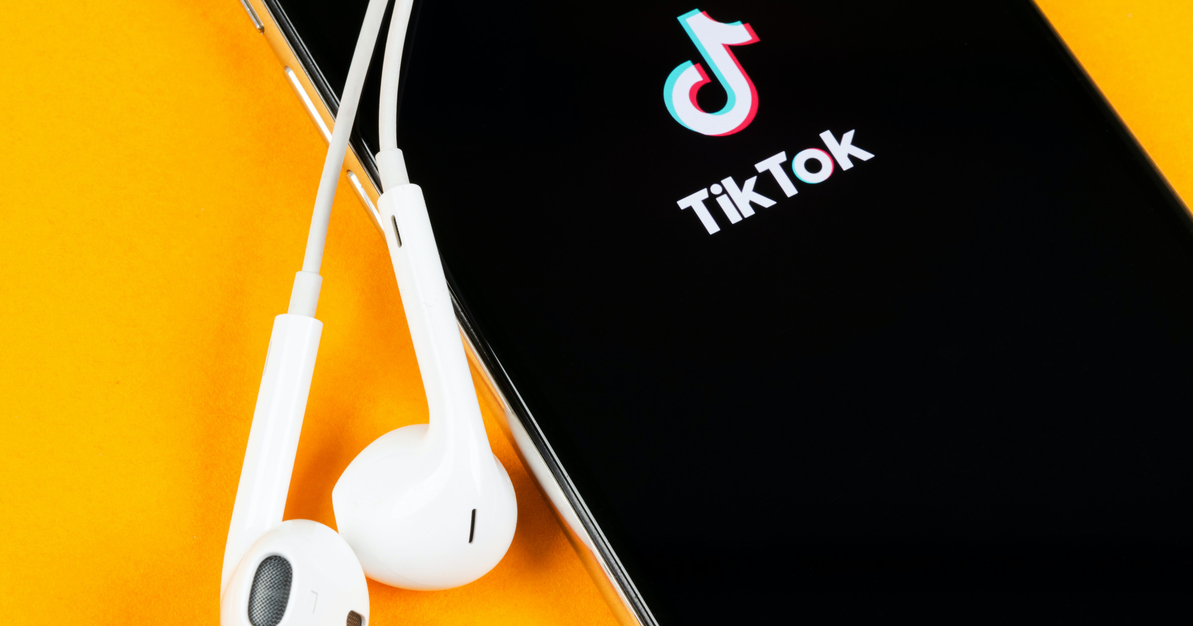 iPhone with TikTok logo and EarPods